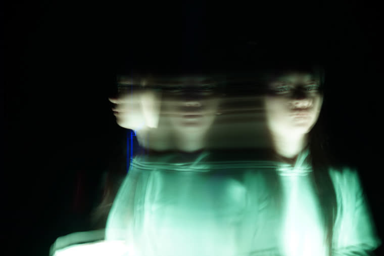 A portrait dragged into teal streaks by a long exposure