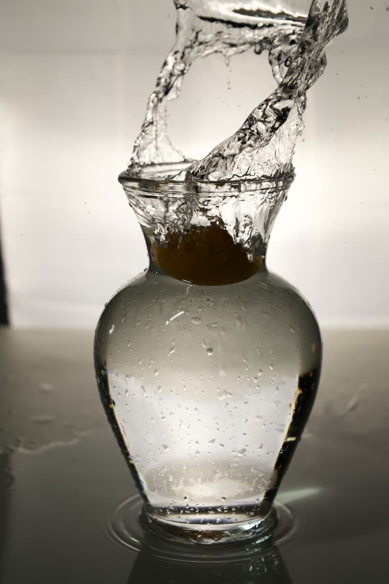 A crown-shaped splash frozen as liquid drops into a glass